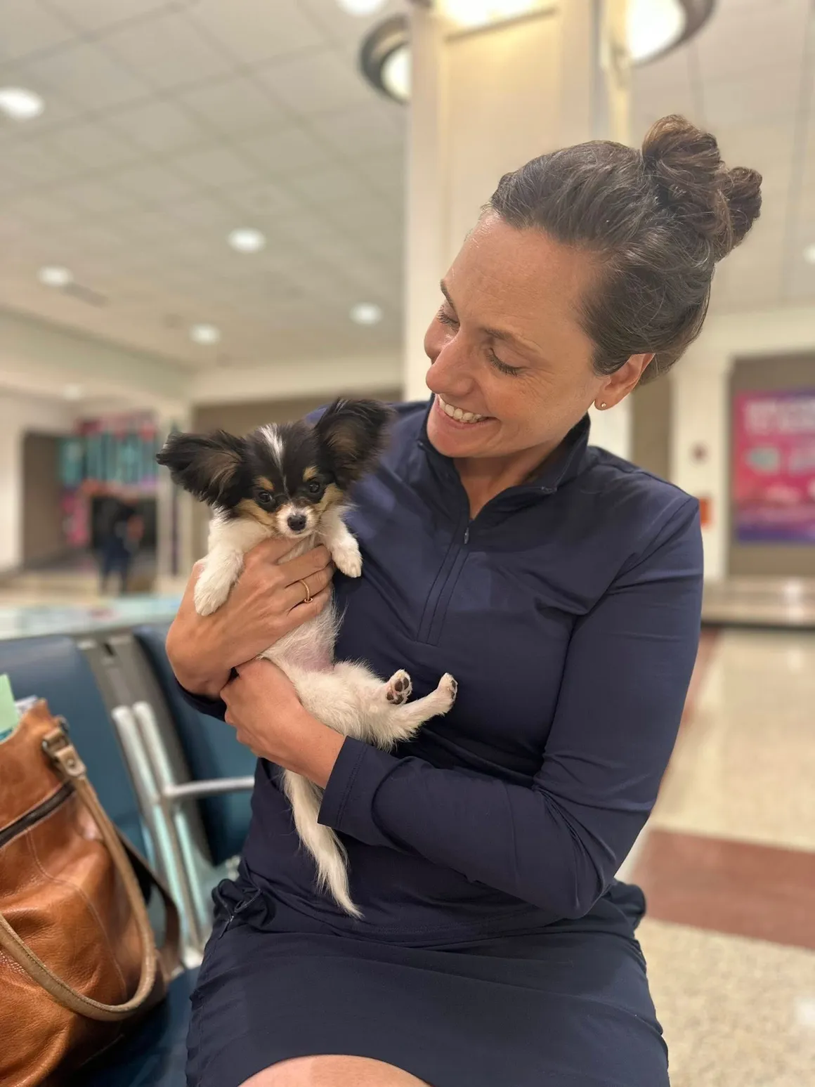 Happy pet parent reunited with puppy at airport